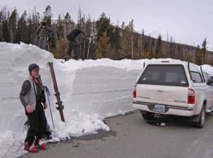 Greg Nelson, left, gathers his gear at the edge of the east entrance road in Yellowstone National Park. Phil Hawkins and Thomas Naberhaus, right, wait for him to join them as they prepare to ski to the summit of Top Notch Peak, overlooking Sylvan Pass. (Ruffin Prevost/WyoFile - click to enlarge)