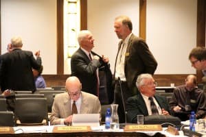 Trustee John MacPherson, at lower right, said trustees voted for open search because of public input and the potential for a law suit if finalists were kept confidential. In the background, Dave Palmerlee talks with trustee Mike Massie of Laramie who wrote the motion to pursue the open search. (Gregory Nickerson/WyoFile)