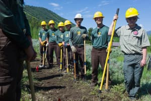 A Montana Conservation Corps Crew listens to U.S. Secretary of Agriculture Tom Vilsack while taking a break from a project on the Bridger-Teton National Forest near Jackson. Crew members get about $1,000 a month for their summer-long jobs. (Angus M. Thuermer Jr./WyoFile)