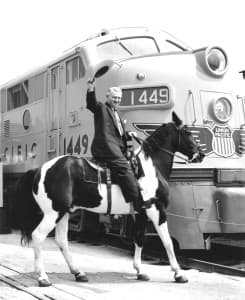 Lester Hunt rides a pinto horse next to a Union Pacific engine, in 1945. He wrote privately in the 1950s that he was being blackmailed over the arrest of his son. (Wyoming State Archives)