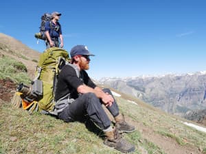 Joe Riis and Arthur Middleton rest while following an elk migration route. The elk cross several mountain passes, thwart predators and ford rivers moving between seasonal territories. Riis and Middleton are working on a documentary about the migration. (courtesy Jenny Nichols)