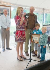 Kathy Lynch and sons Max and Will receive the rising-star award for their late husband and father Luke Lynch at a ceremony at the Murie Center on Thursday. John Turner, background. former director of the U.S. Fish and Wildlife Service received the Murie Spirit of Conservation Award. Center director Paul Hansen, center, announced the merger of the center and Teton Science Schools at the ceremony. (Angus M. Thuermer Jr./WyoFile)
