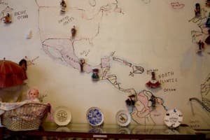 A mural painted on a wall in the Little Snake River Museum shows a collection of dolls, and the home countries of many of the area's agricultural workers. (Gregory Nickerson/WyoFile)