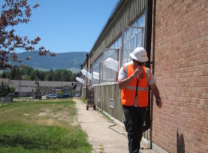 A worker at Kelly Walsh High School in Casper — which is undergoing a major expansion — dons personal protective wear. Several industries, including construction, have voluntarily formed safety programs with the state of Wyoming. (Dustin Bleizeffer/WyoFile)