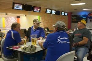 A bowling team at the Tuesday night Cowboy Bowling League in Gillette. Behind them are empty chairs and tables. The shrinking league is down ten guys from the year before.