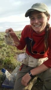 Lindsey Sanders holds up a ground squirrel, while conducting research on rodents and sagebrush songbirds. (Anna Chalfoun) 
