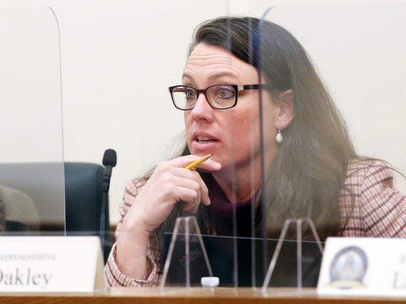Ember Oakley at a desk behind fiberglass