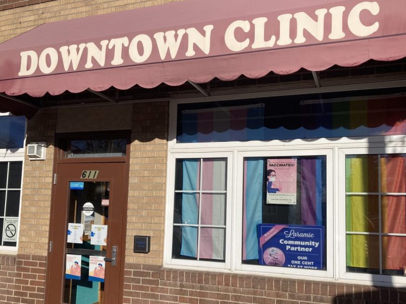 The front windows of the Downtown Clinic are partially covered with the LGBTQ rainbow pride flag and transgender pride flag