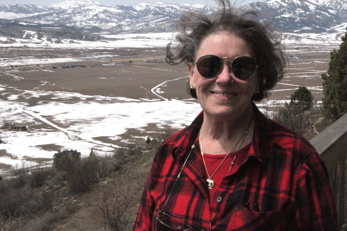 Marti Halverson stands outside before a snowy, windy Wyoming landscape