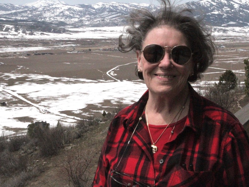 Marti Halverson stands outside before a snowy, windy Wyoming landscape