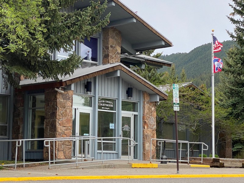 The front doors at the Teton County Courthouse, framed by trees