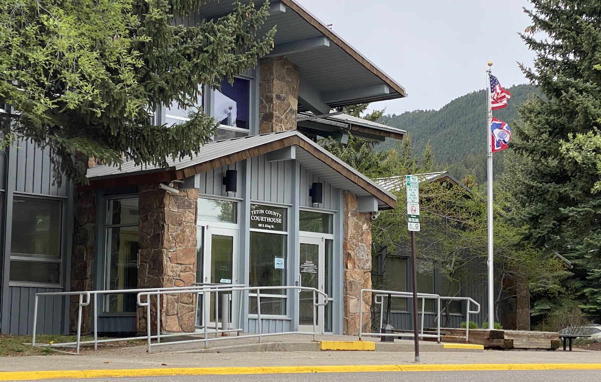 The front doors at the Teton County Courthouse, framed by trees