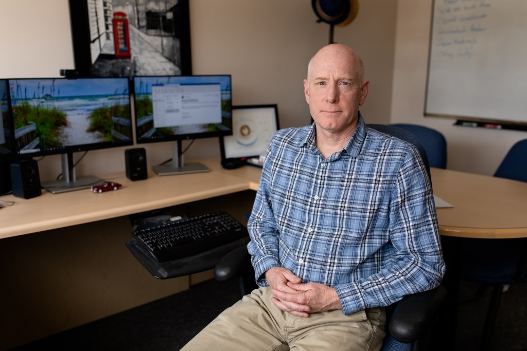 Rodney Wambeam sits at his desk at WYSAC headquarters in Laramie