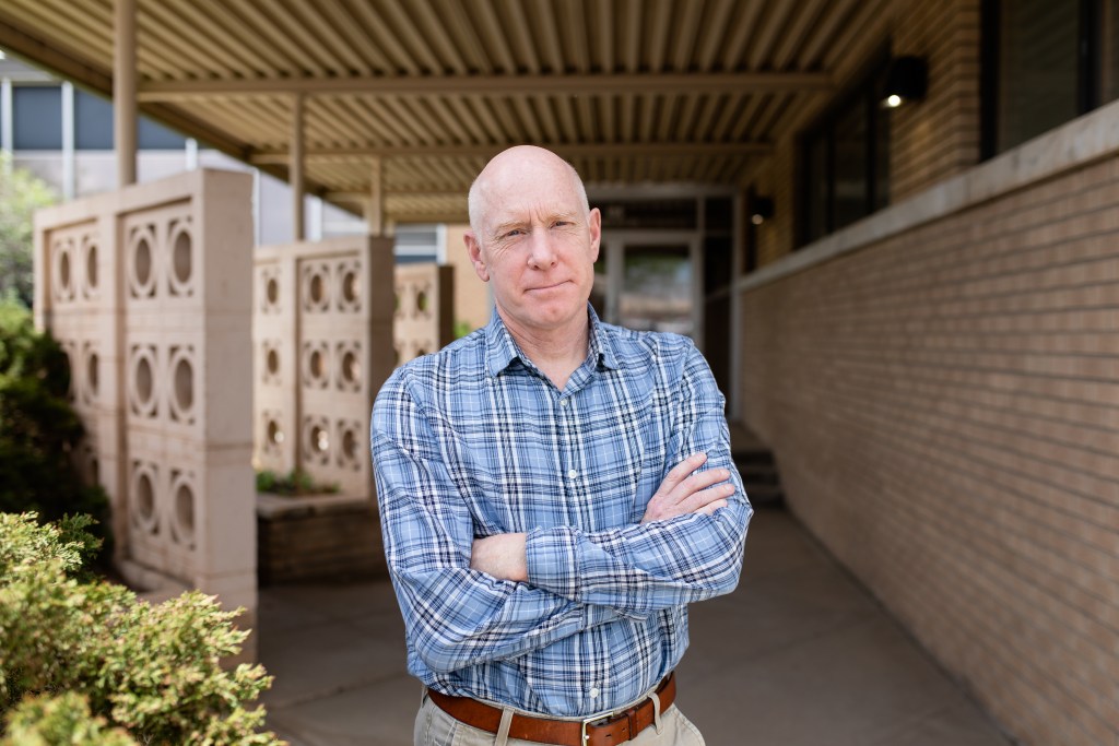 Rodney Wambeam stands in front of WYSAC headquarters on a sunny day
