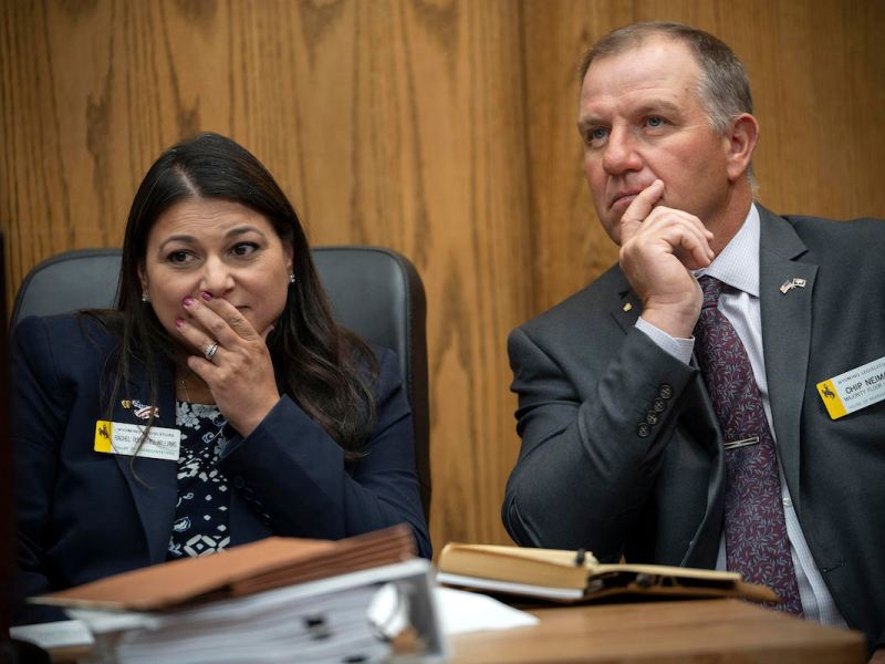 Reps. Rachel Rodriguez-Williams and Chip Neiman sit in court with their hands on their faces