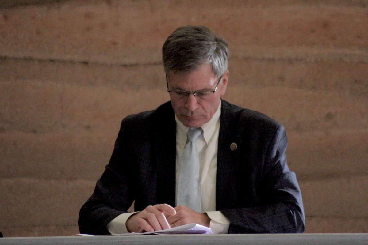 Governor Gordon looks through pieces of paper on the table in front of him