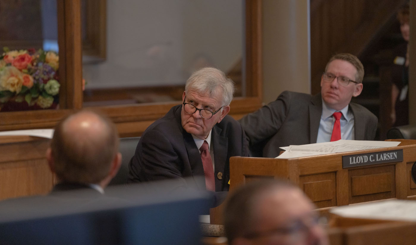 Lloyd Larsen sits forward at his desk on the House floor