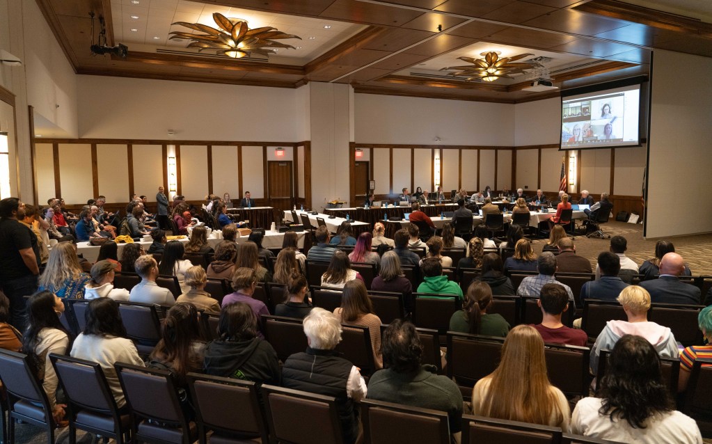 A room packed with people sitting and standing