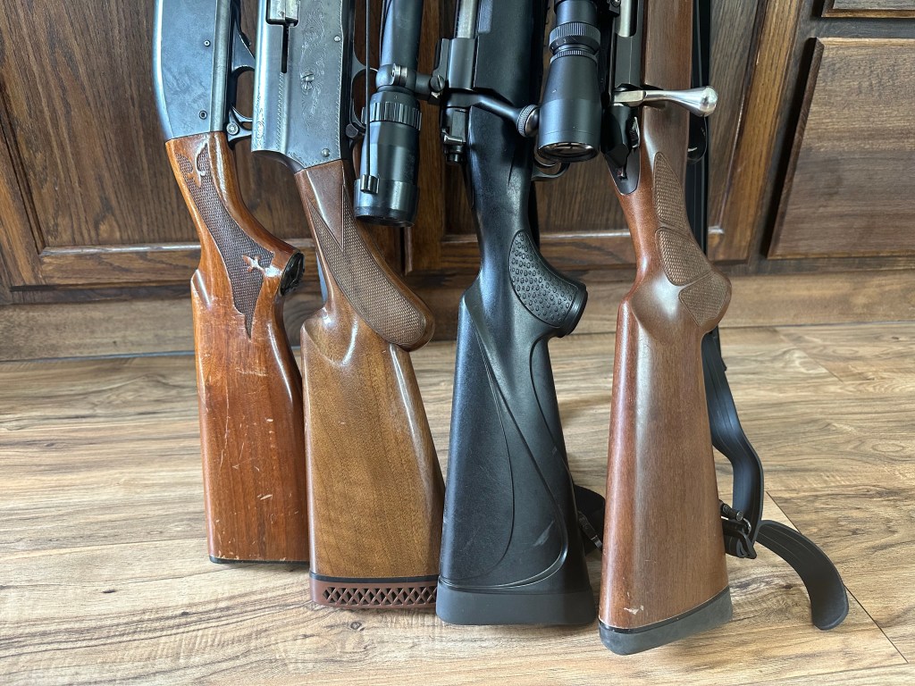 Four gun stocks lines up on the ground