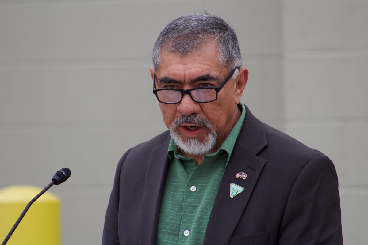 A man stands and talks at a podium