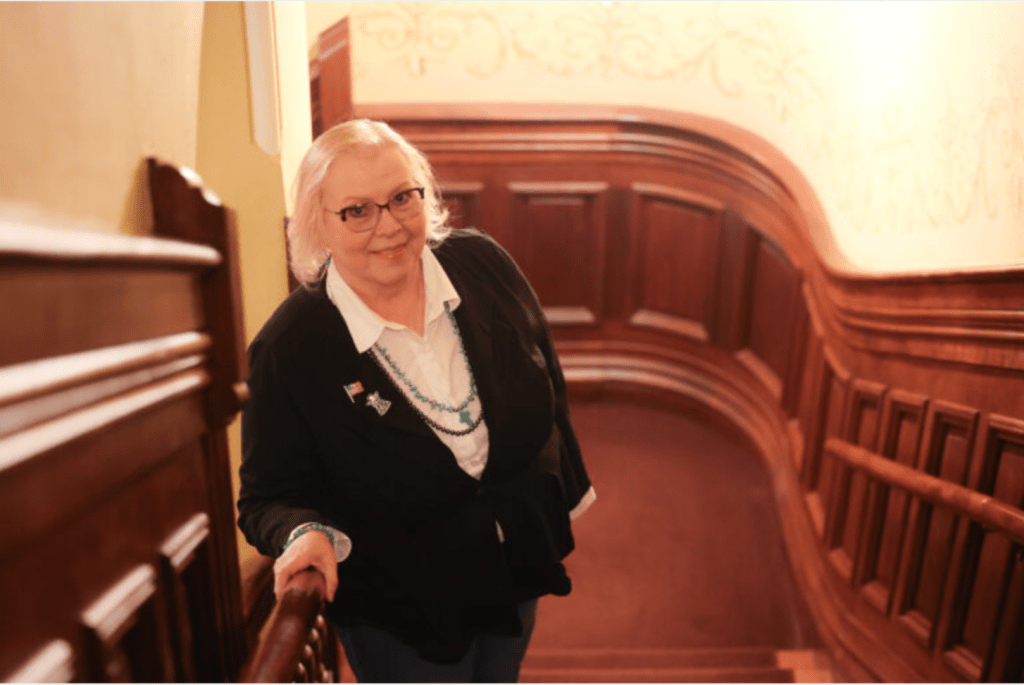 A woman stands in stairwell at the legislature