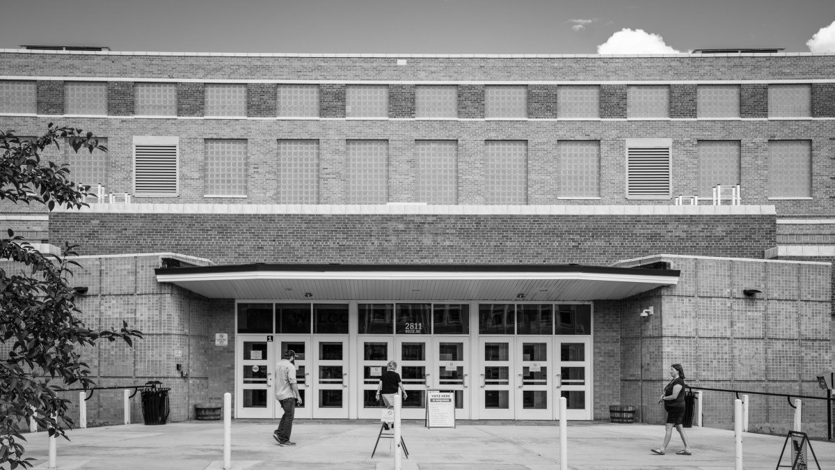 The outside view of a brick building and voting signs