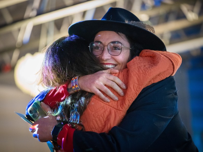 Two women hug and one has a nice hat