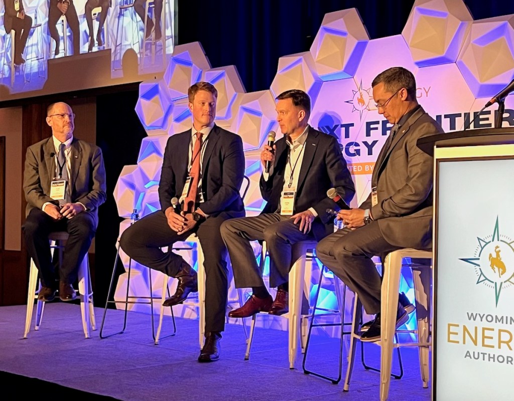 U.S. Environmental Protection Agency Region 8 Administrator Cyrus Western, in the red tie, joins a panel discussion at an energy conference in Laramie on May 6, 2025. (Dustin Bleizeffer/WyoFile)