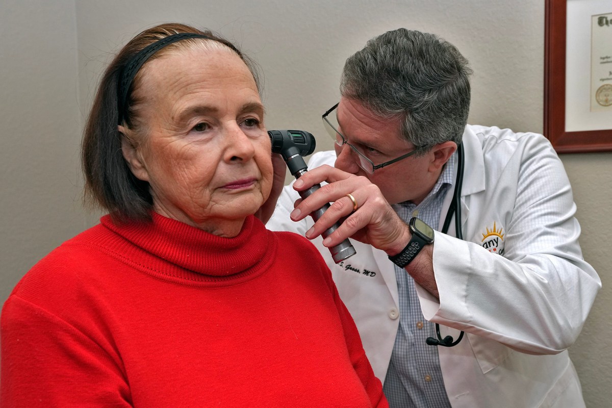A doctor check's a patient's ears.