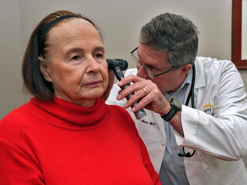 A doctor check's a patient's ears.